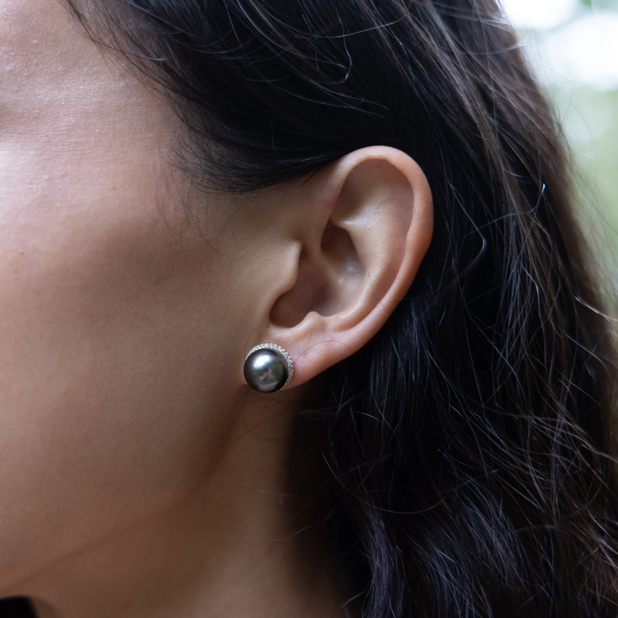 Ear wearing a diamond halo Tahitian black pearl earring