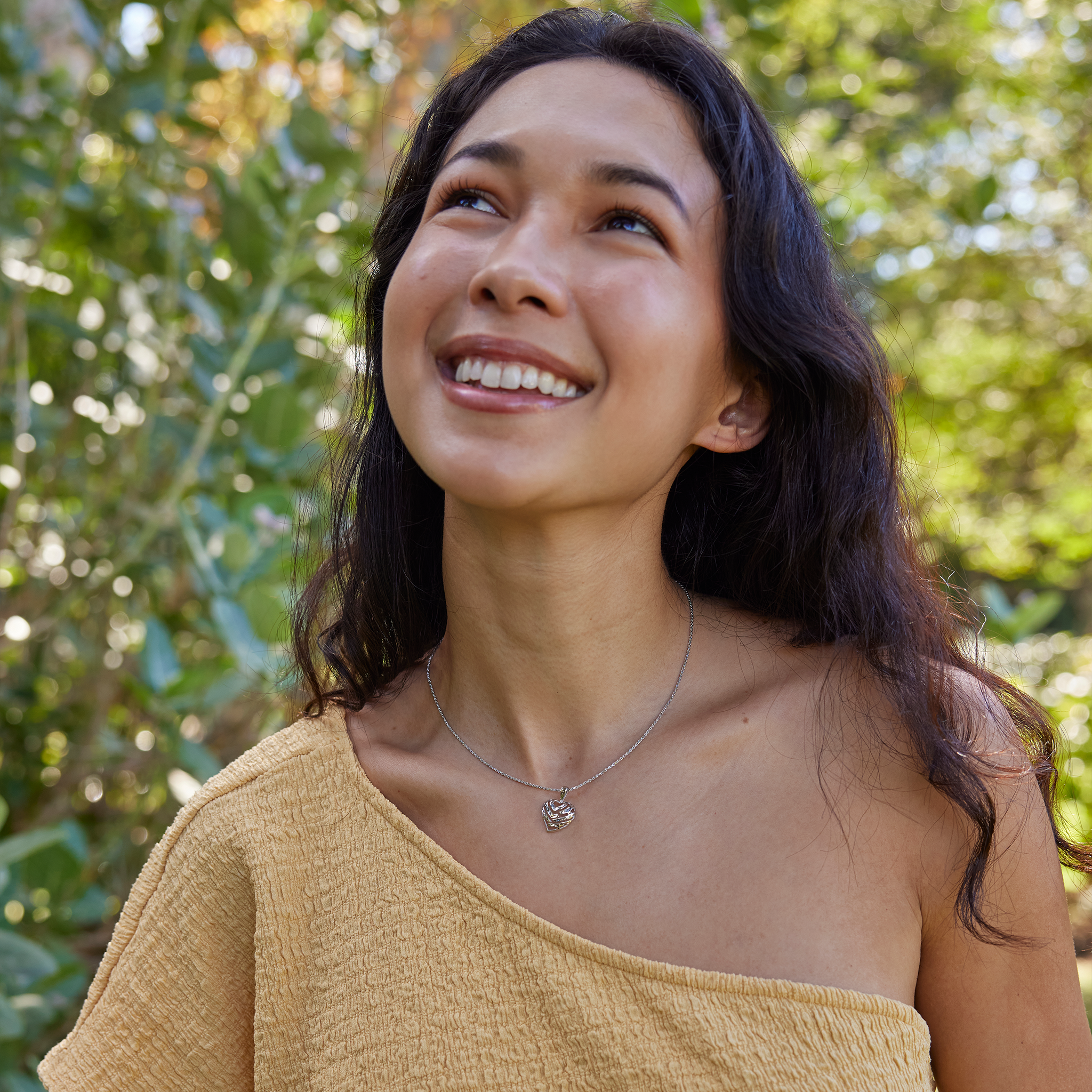 Close-up of a woman wearing an Aloha Heart Pendant with cut-out design spelling "Aloha" in 14k White Gold on chain