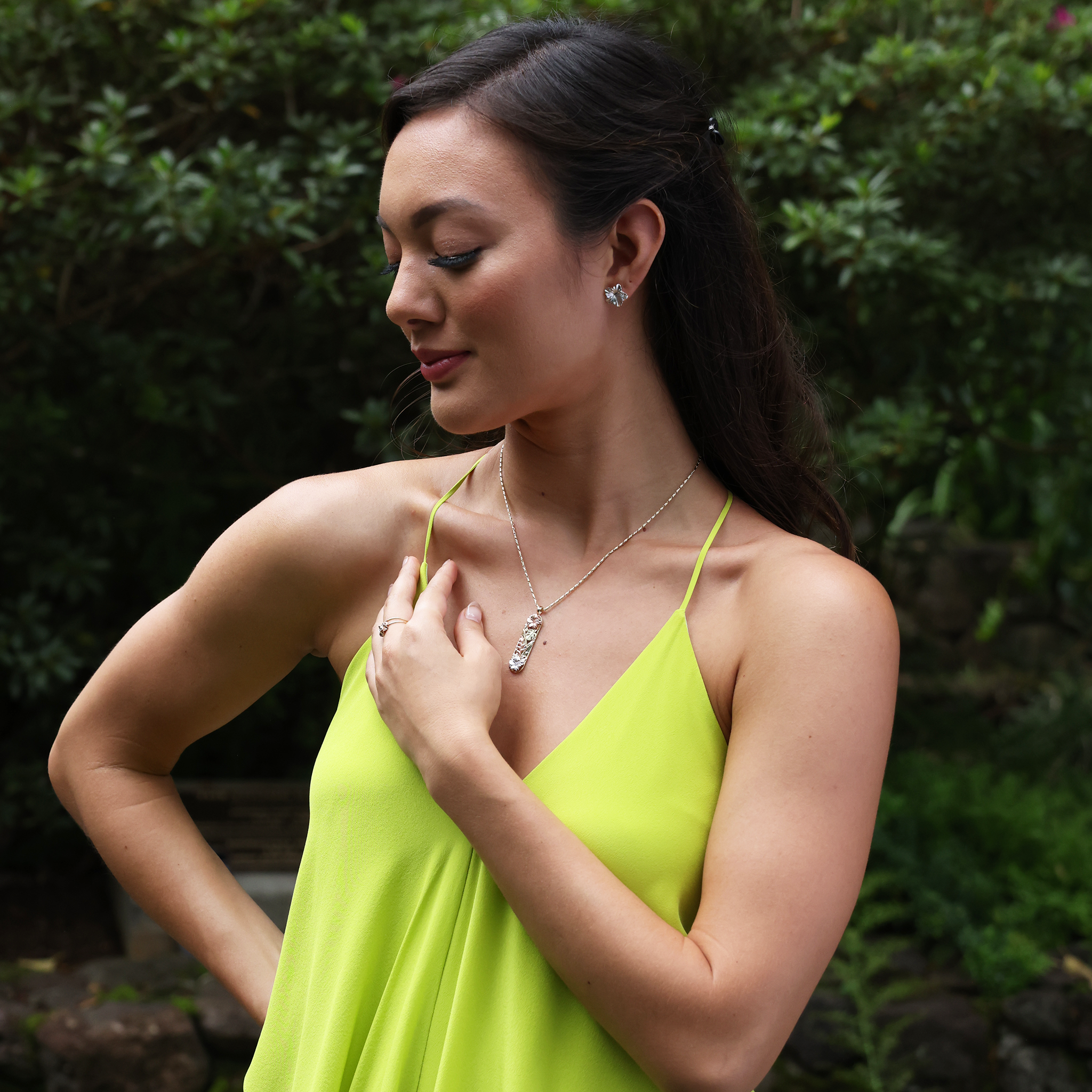A woman wearing a Hawaiian Gardens Hibiscus Pendant in Multi Color Gold with matching earring and rings