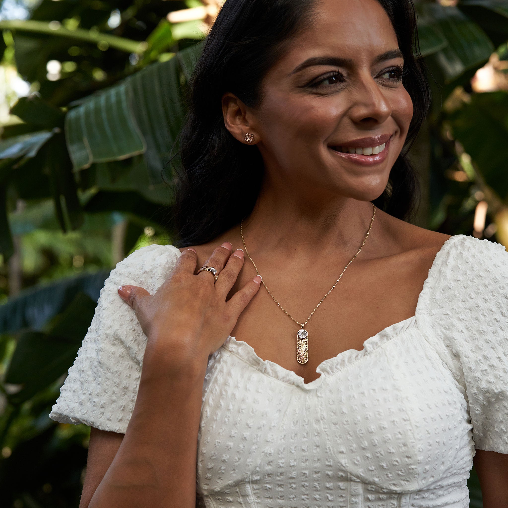 Woman in tropical garden wearing Hawaiian Gardens Hibiscus Pendant in Multi Color Gold with Diamonds