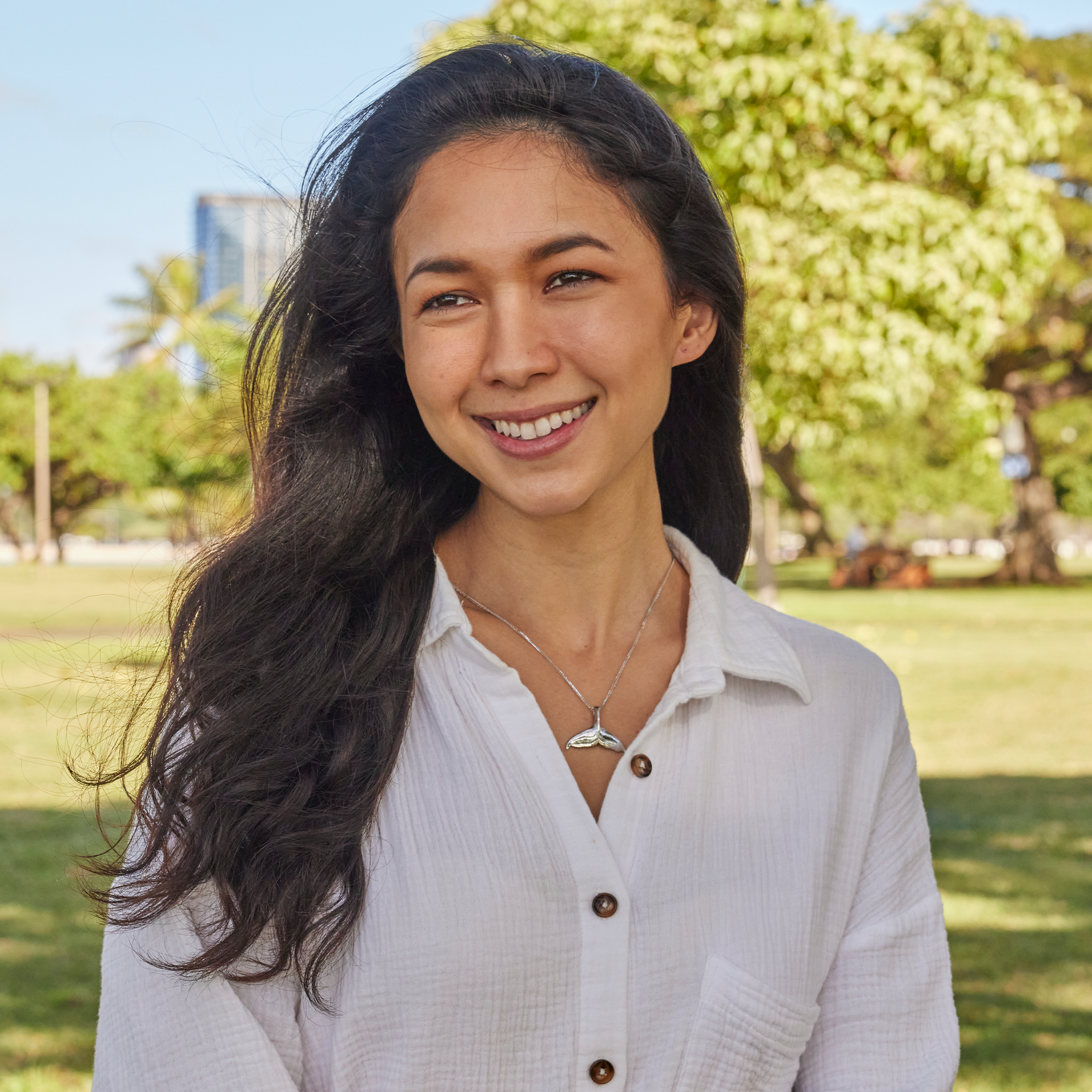 Woman in a park wearing a white gold whale tail pendant