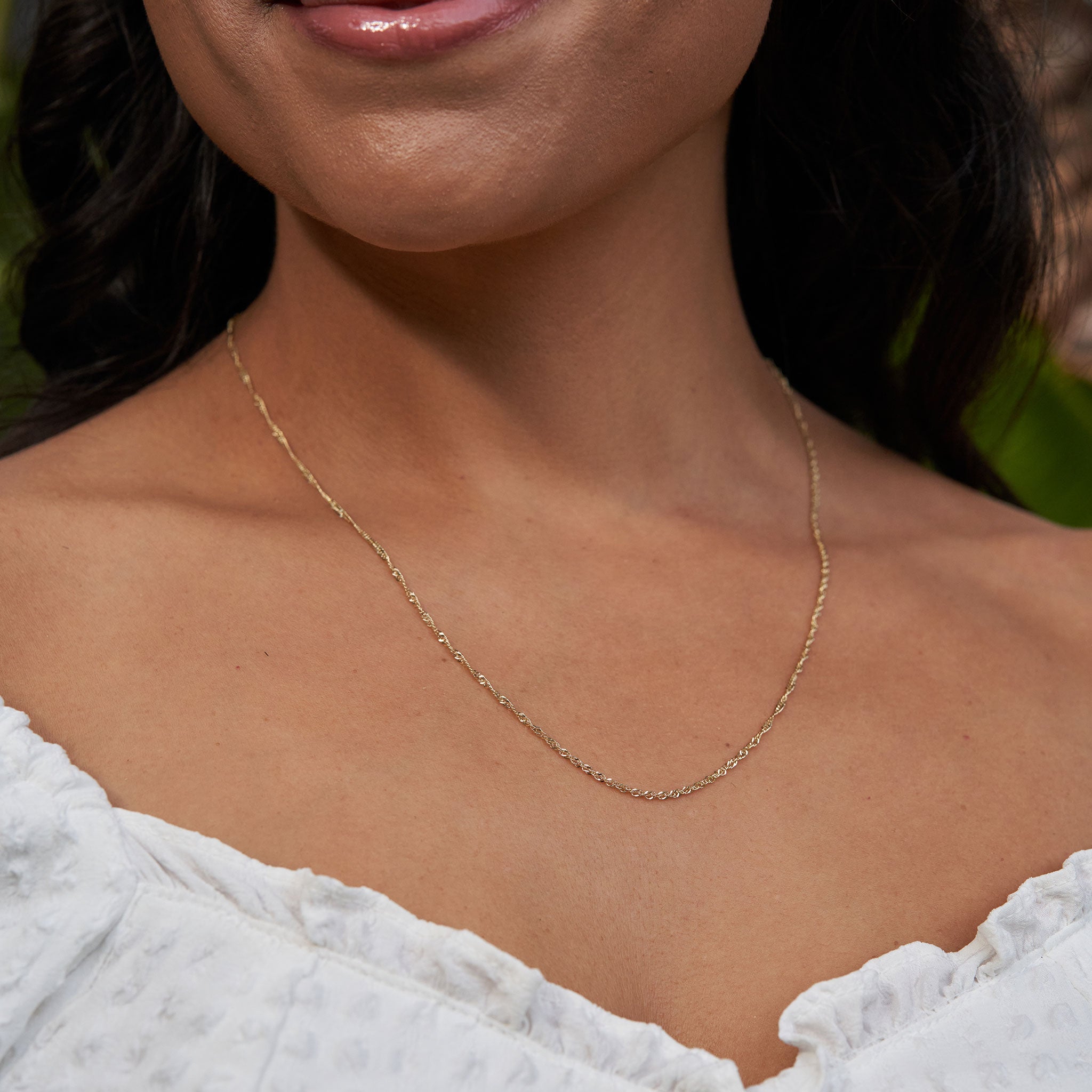 Close up of 1.5mm Singapore Chain in Gold on woman's chest