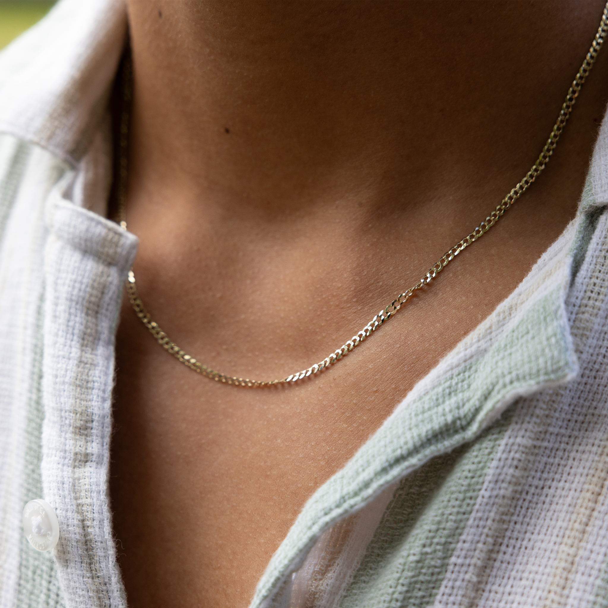 Close up of 2.5mm Curb Chain in 14k Yellow Gold on a person's chest