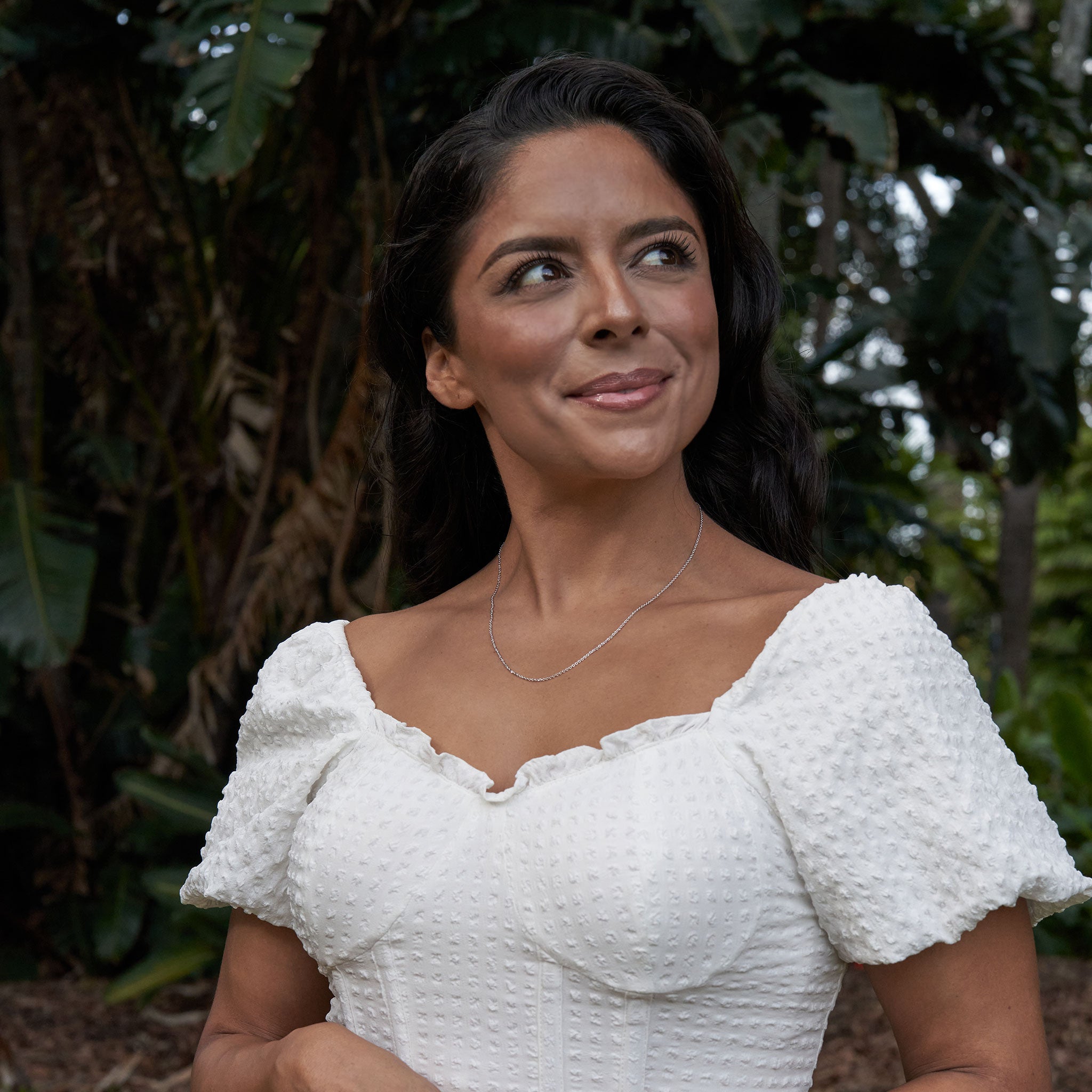 Woman in a tropical garden wearing Adjustable 24" 1.0mm Cable Chain in Sterling Silver