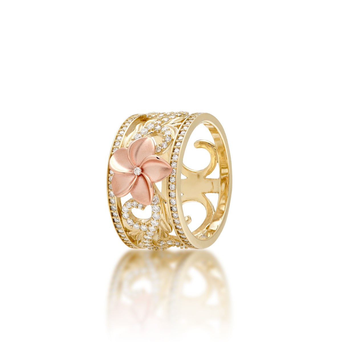 A 14k Yellow Gold Hawaiian Heirloom Ring with a 14k diamond-accented plumeria flower at the crown and diamond maile leaf and fern scrollwork with rows of diamonds on each side of the ring, shown on a white background