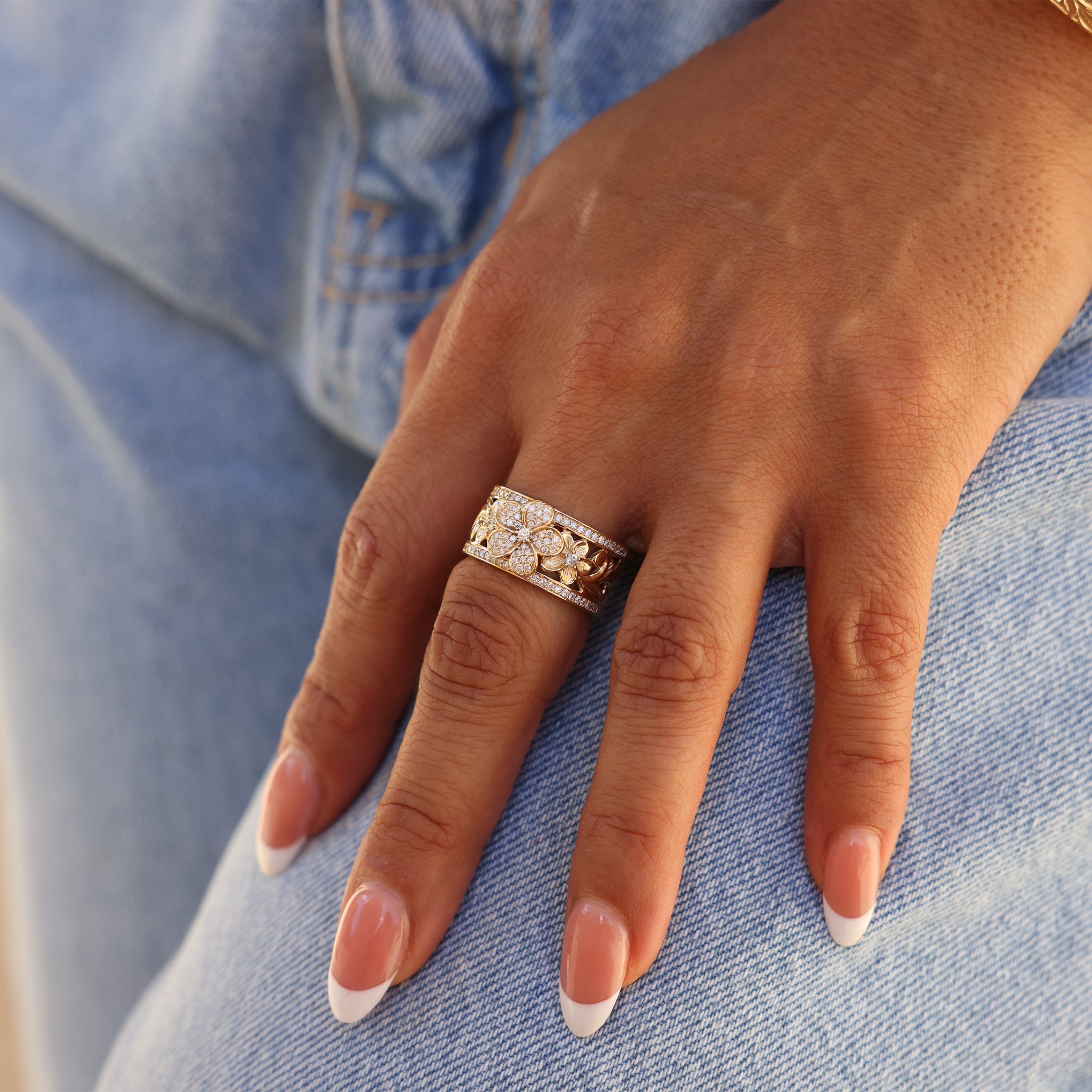 Hawaiian Heirloom Plumeria Engagement Ring in Gold with Diamonds on Hand touching jeans