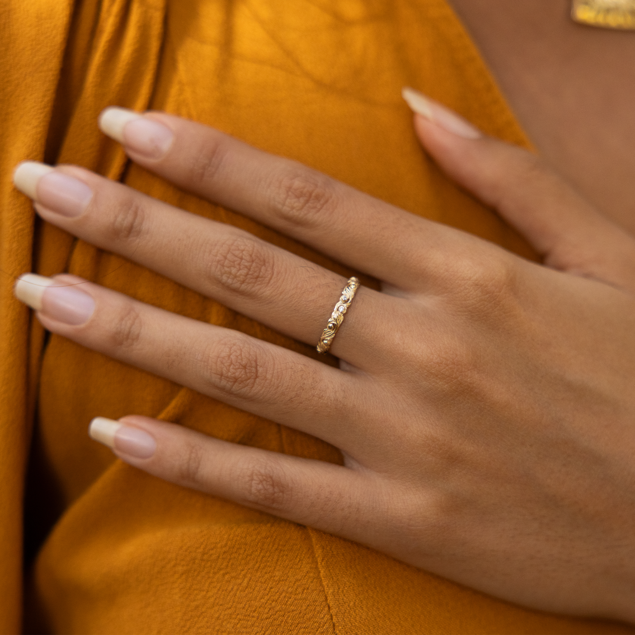 Living Heirloom Ring in Gold with Diamonds on a woman's hand resting on her chest