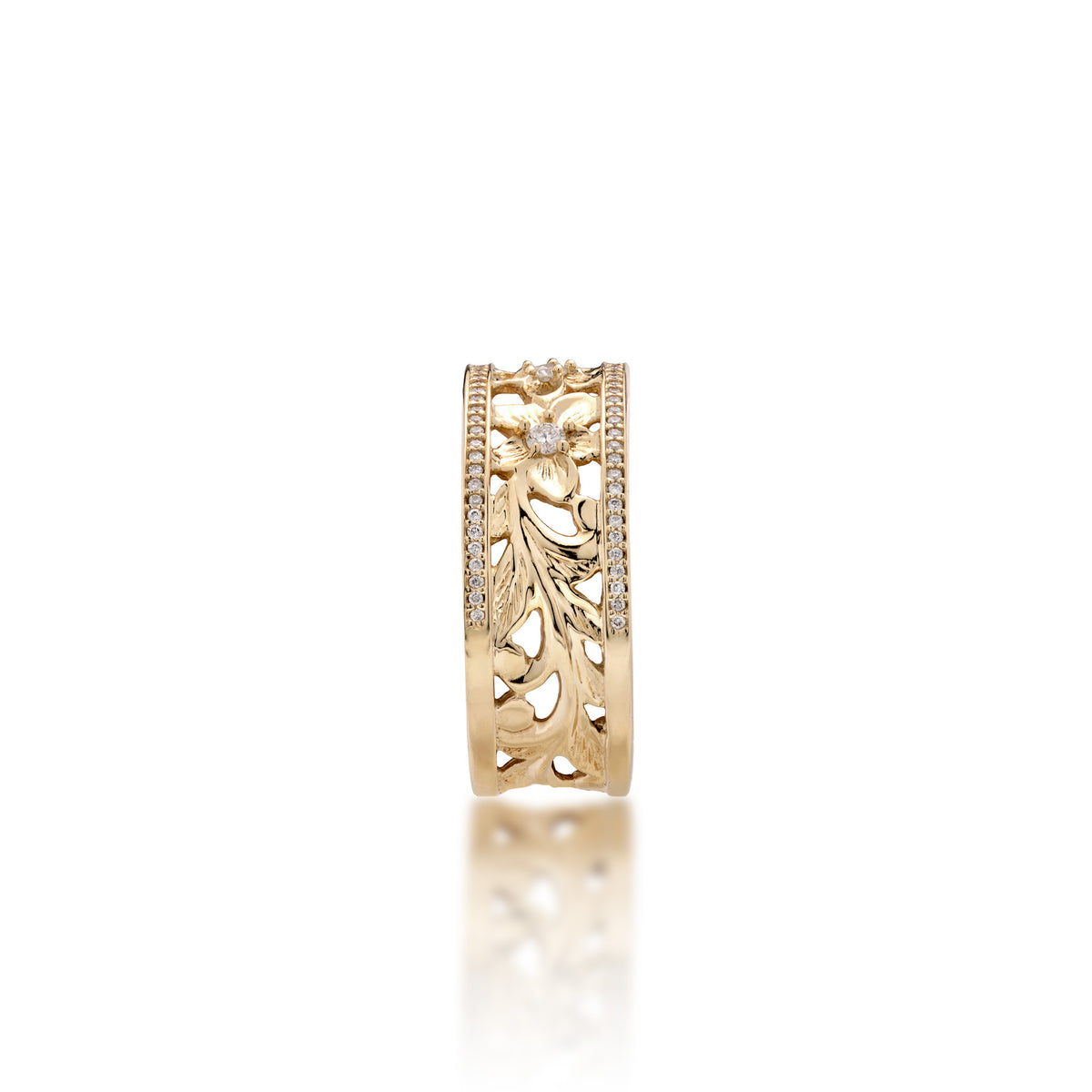 A side view of a 14k yellow gold Hawaiian Heirloom Ring ring diamond-accented plumeria flowers at the top and fern and maile leaf scrollwork at the bottom and a row of pave set diamonds on each side of the band, shown on a white background