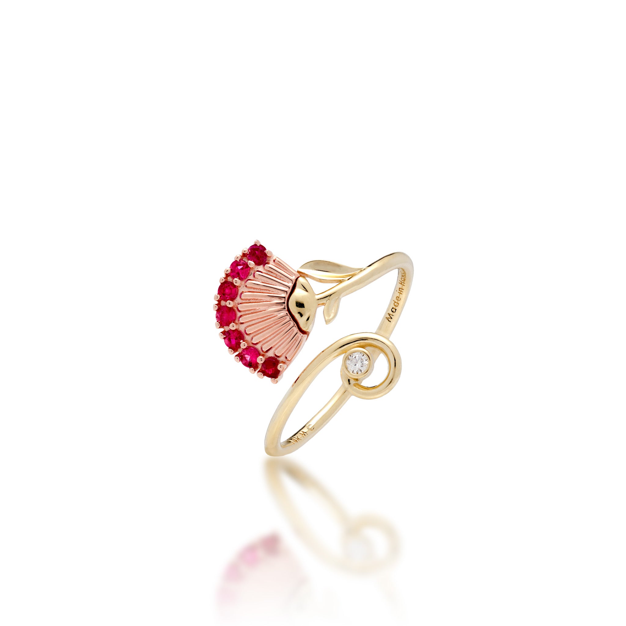 An ʻŌhiʻa Lehua Flower Ring with a 14k Rose gold flower set with red rubies and a high-polish 14k yellow gol dband with a curling end set with a diamond, shown on a white background