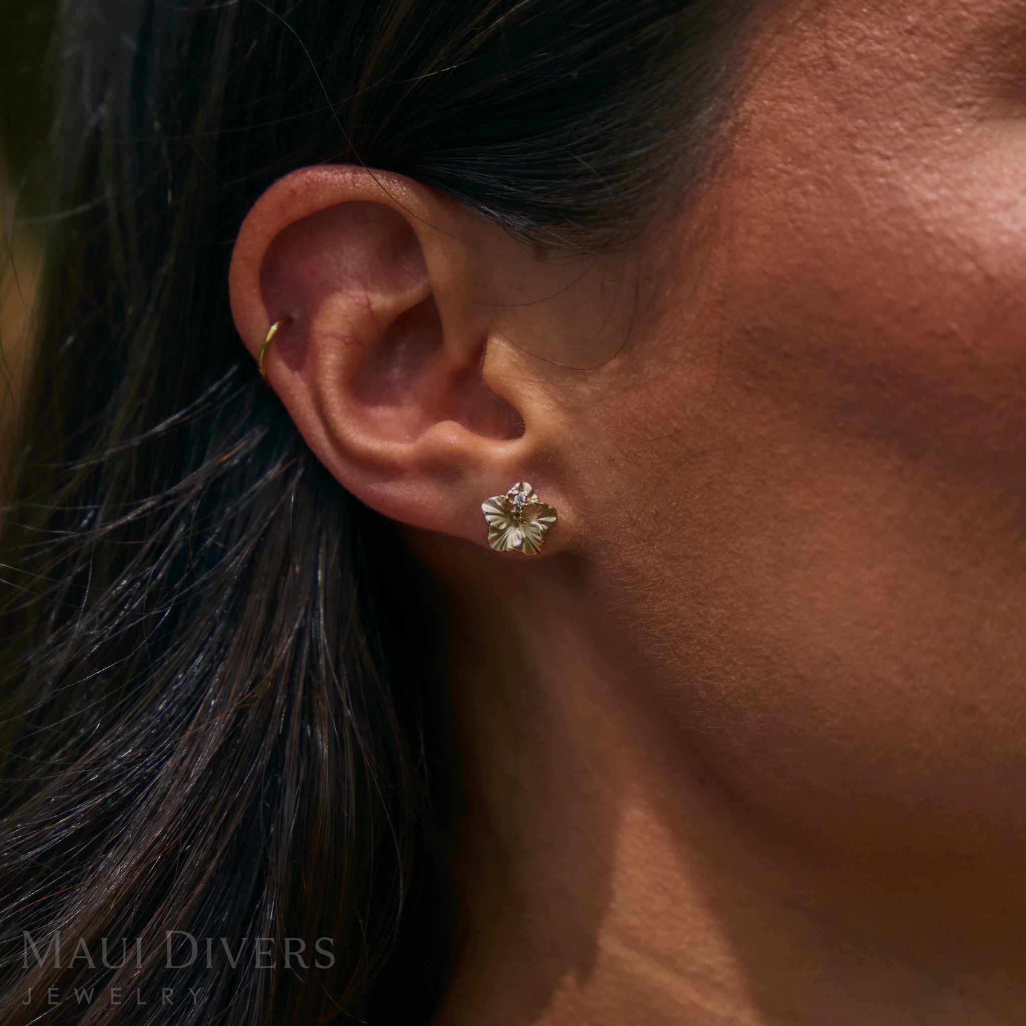 Close up of 9.5mm Diamond Hibiscus Earrings in 14k Yellow Gold on ear