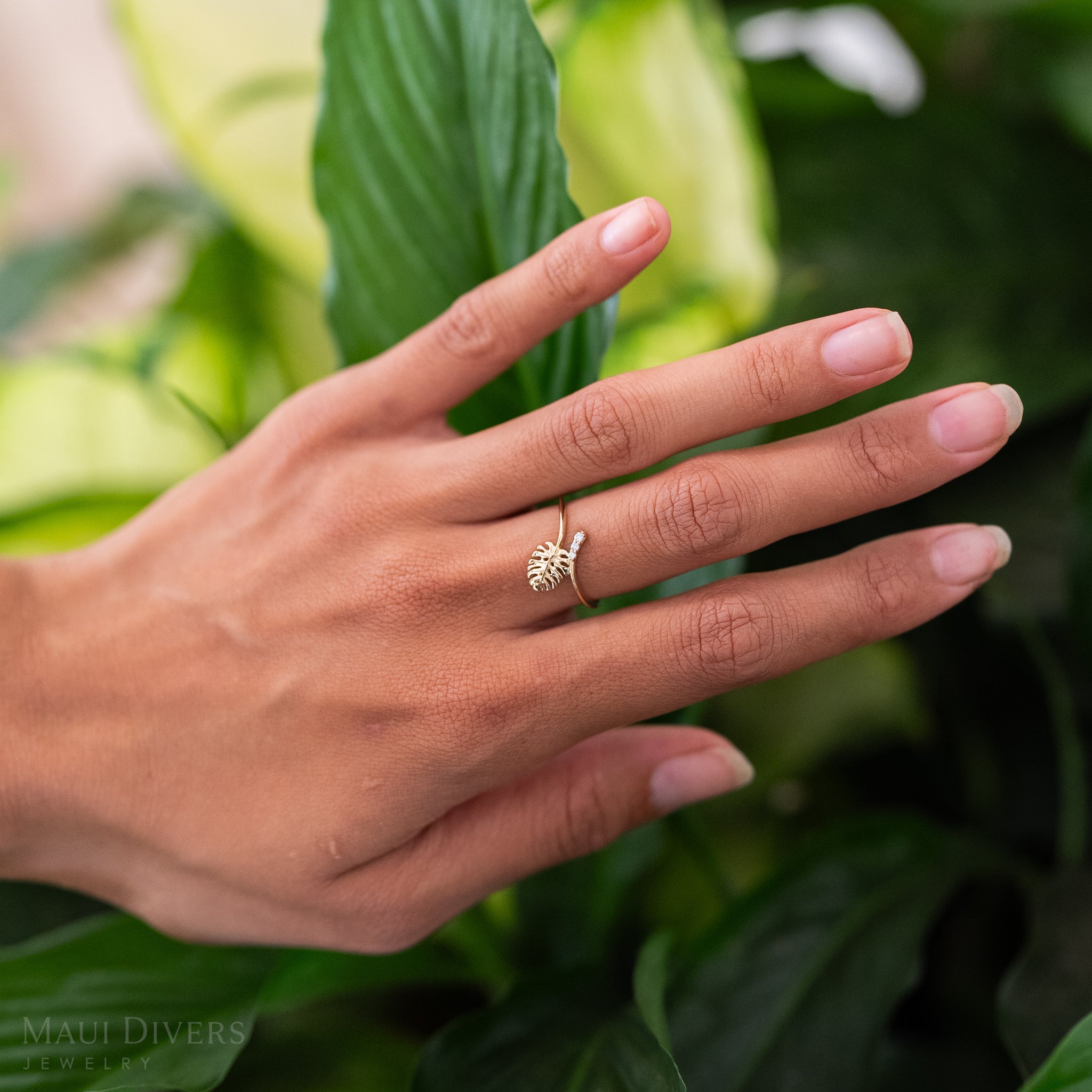 9mm Monstera Ring in Gold with Diamonds on a hand with leafy greens in the background