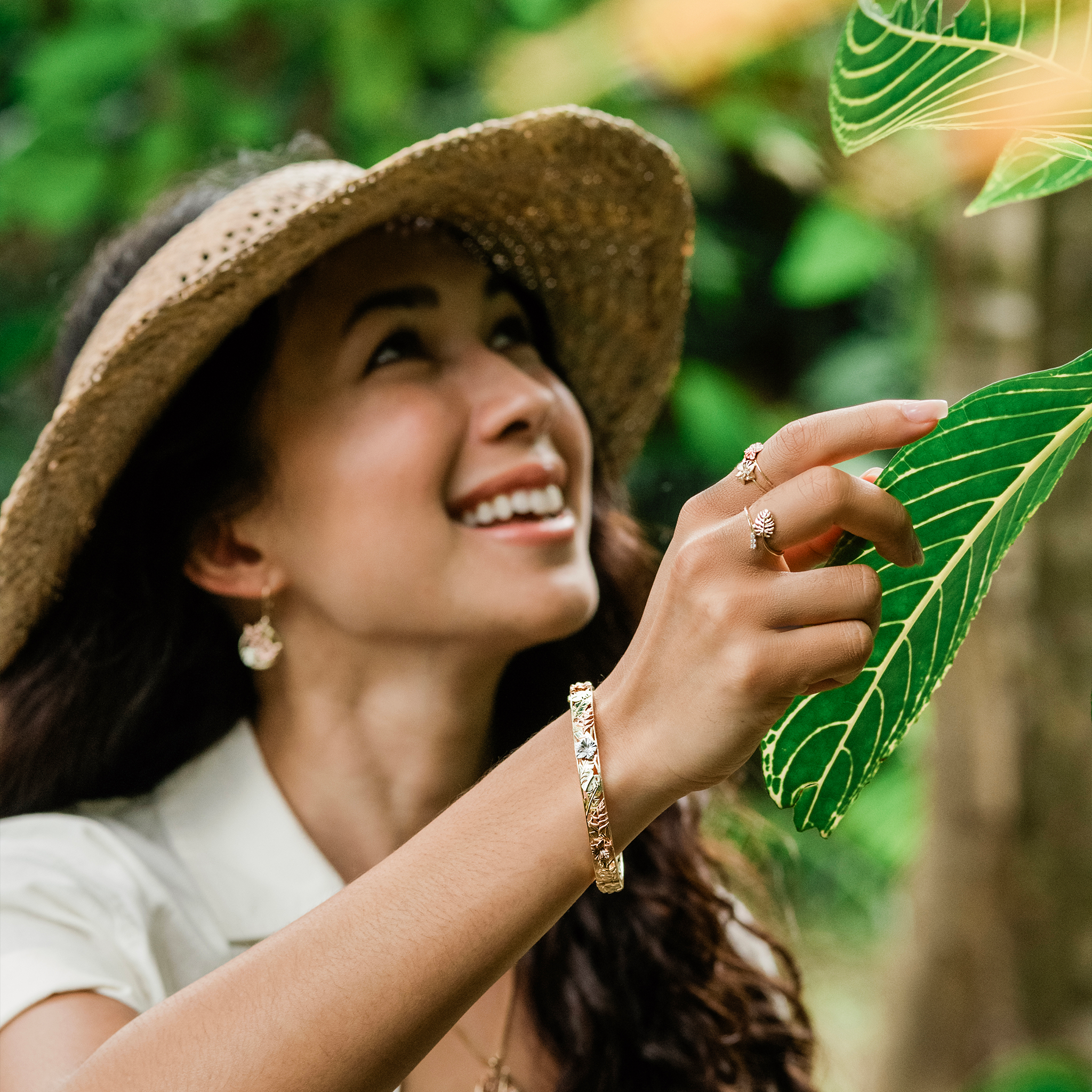 Hawaiian Gardens Hibiscus Ring and Bracelet in Gold with Diamonds on a woman in a tropical garden