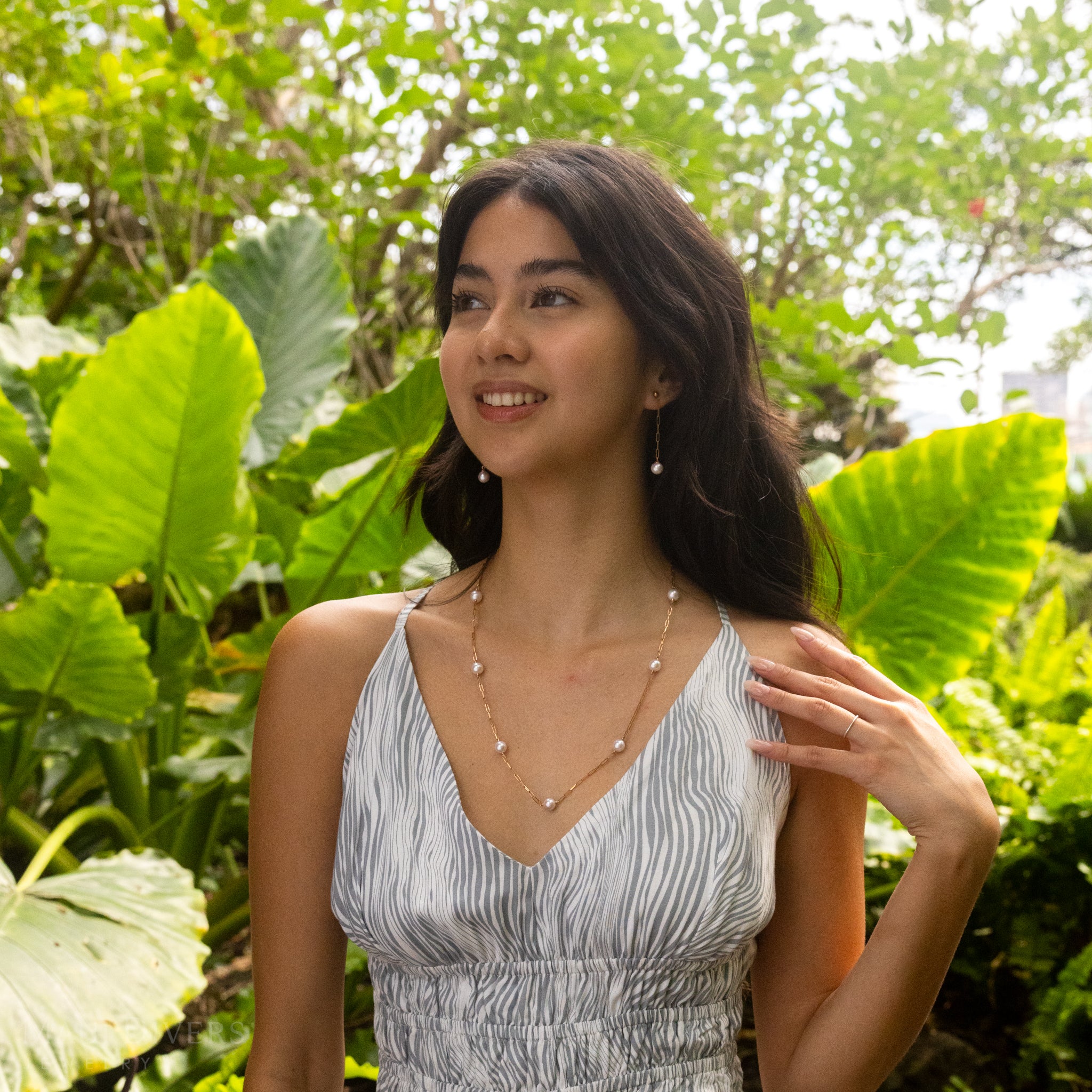 Akoya White Pearl Paperclip Chain Earrings and Necklace in Rose Gold on a woman in a tropical garden