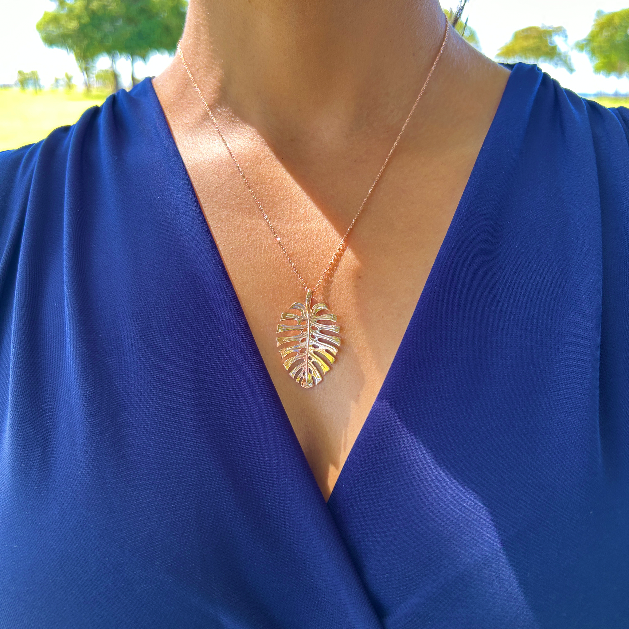 A woman wearing a necklace with a 0.8mm Baby Rope Chain in Rose Gold pendant from Maui Divers Jewelry.