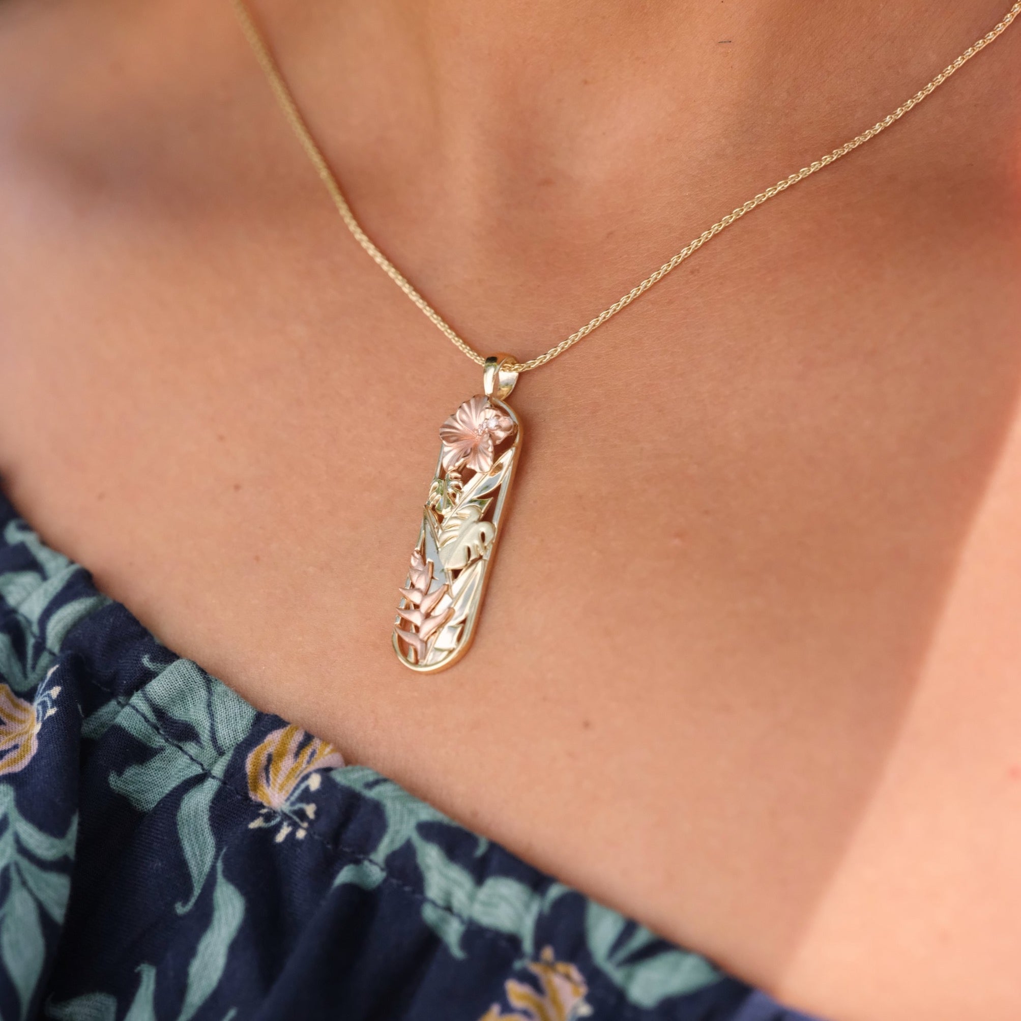 A woman's neck with a Hawaiian Gardens Hibiscus Pendant in Tri Color with Diamonds