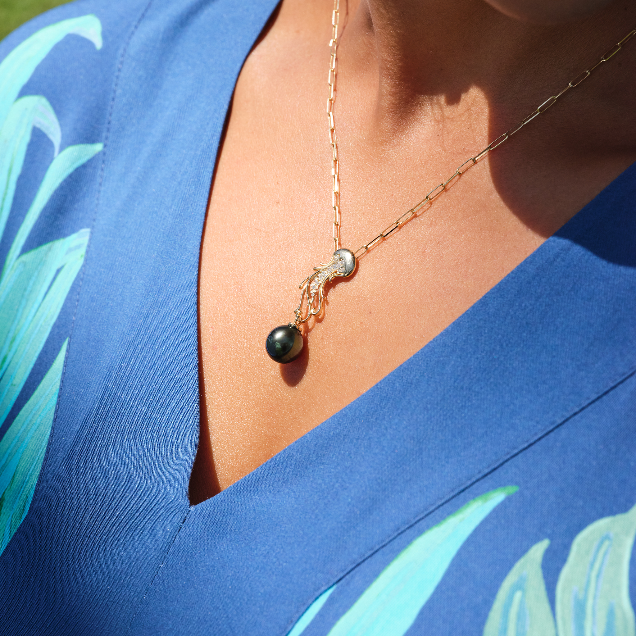 A woman wearing an Ocean Dance Jellyfish Tahitian Black Pearl Pendant in Gold with Diamonds - 9-10mm - Maui Divers Jewelry