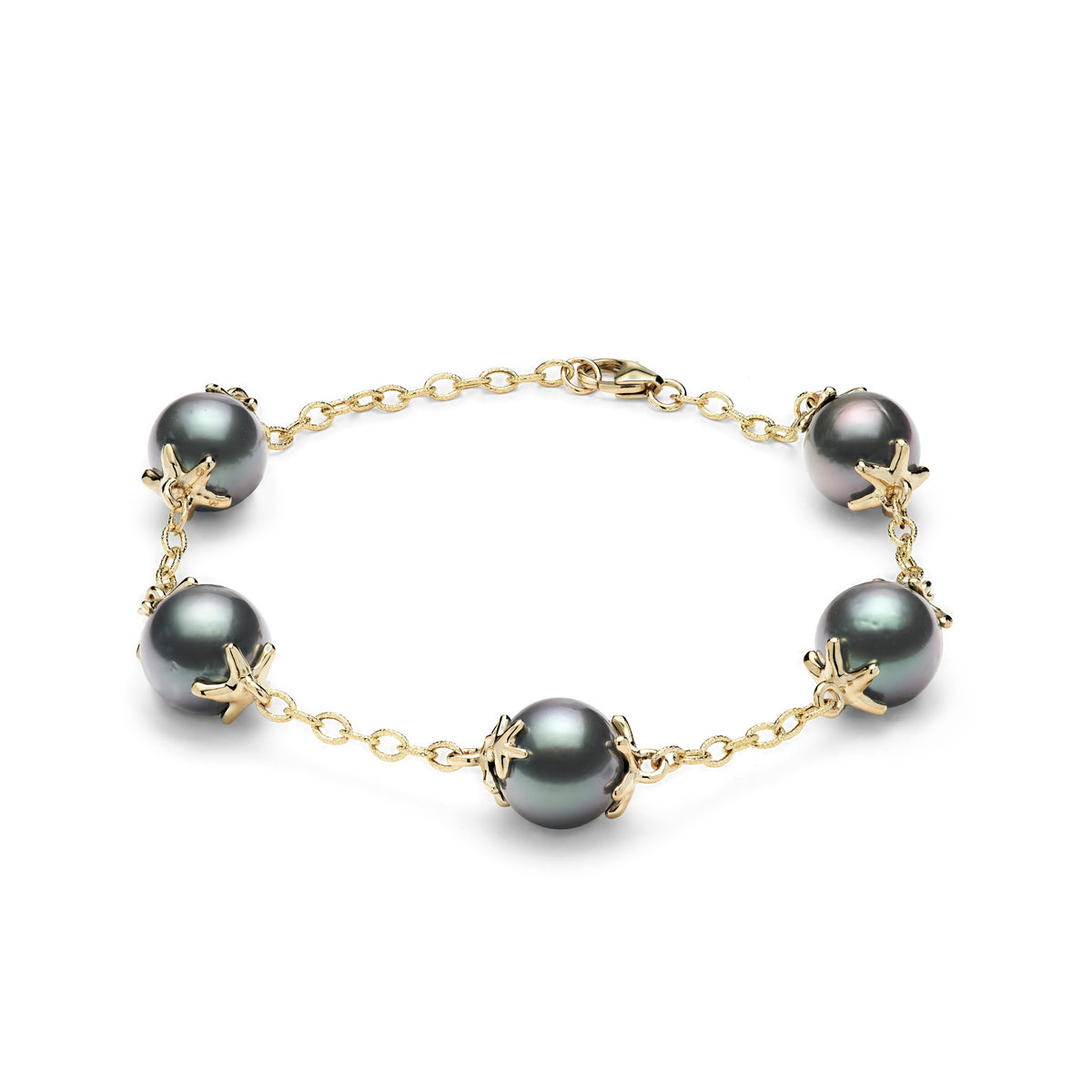A 14k yellow gold link bracelet with Tahitian black pearls and starfish mounted onto each side of the pearl, shown on a white background