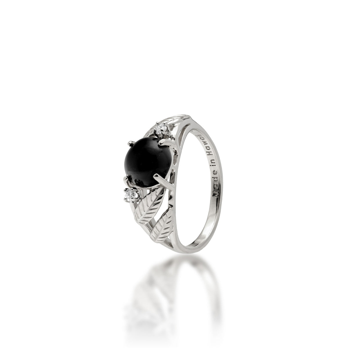 A 14k white gold ring with a round 7mm Hawaiian black coral gem at the crown, a diamond on each side, and diamond-cut maile leaves along the sides of the band, shown on a white background
