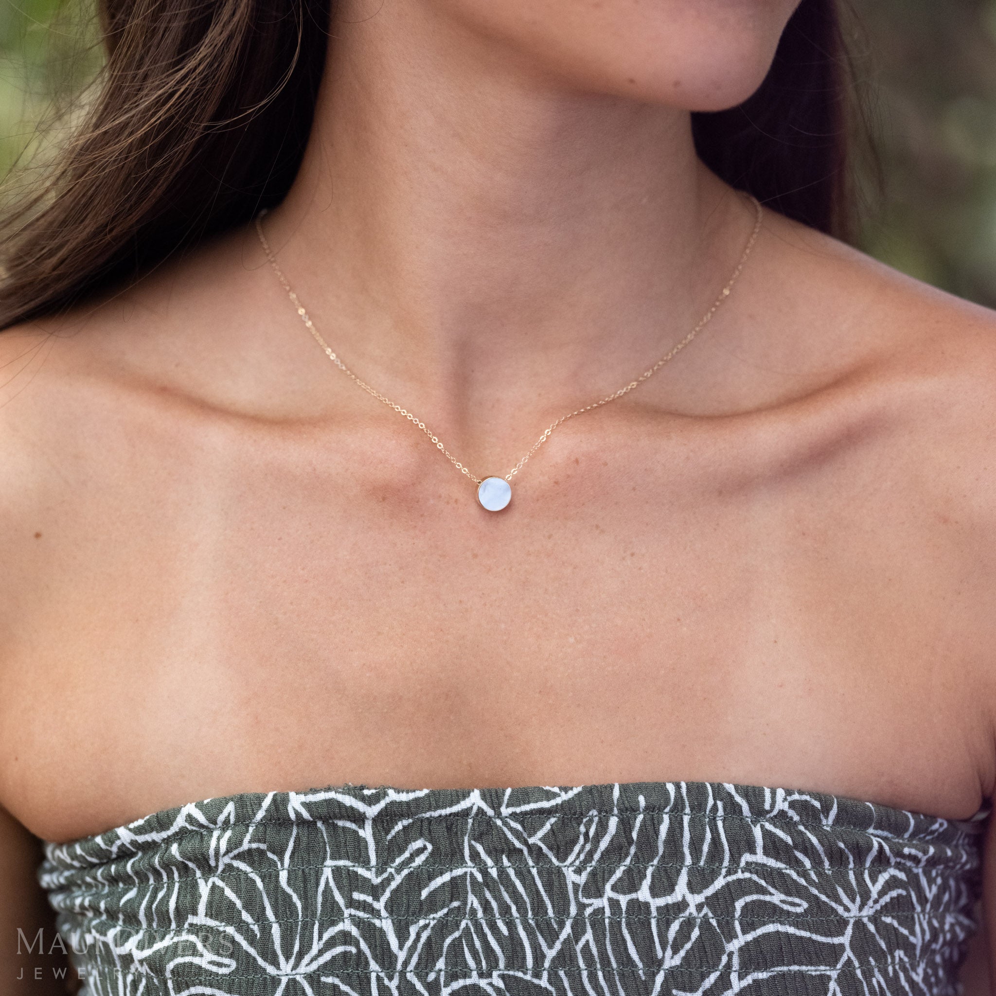 Close up of Eclipse Flipside Necklace in 14k Gold on the Mother of Pearl side.