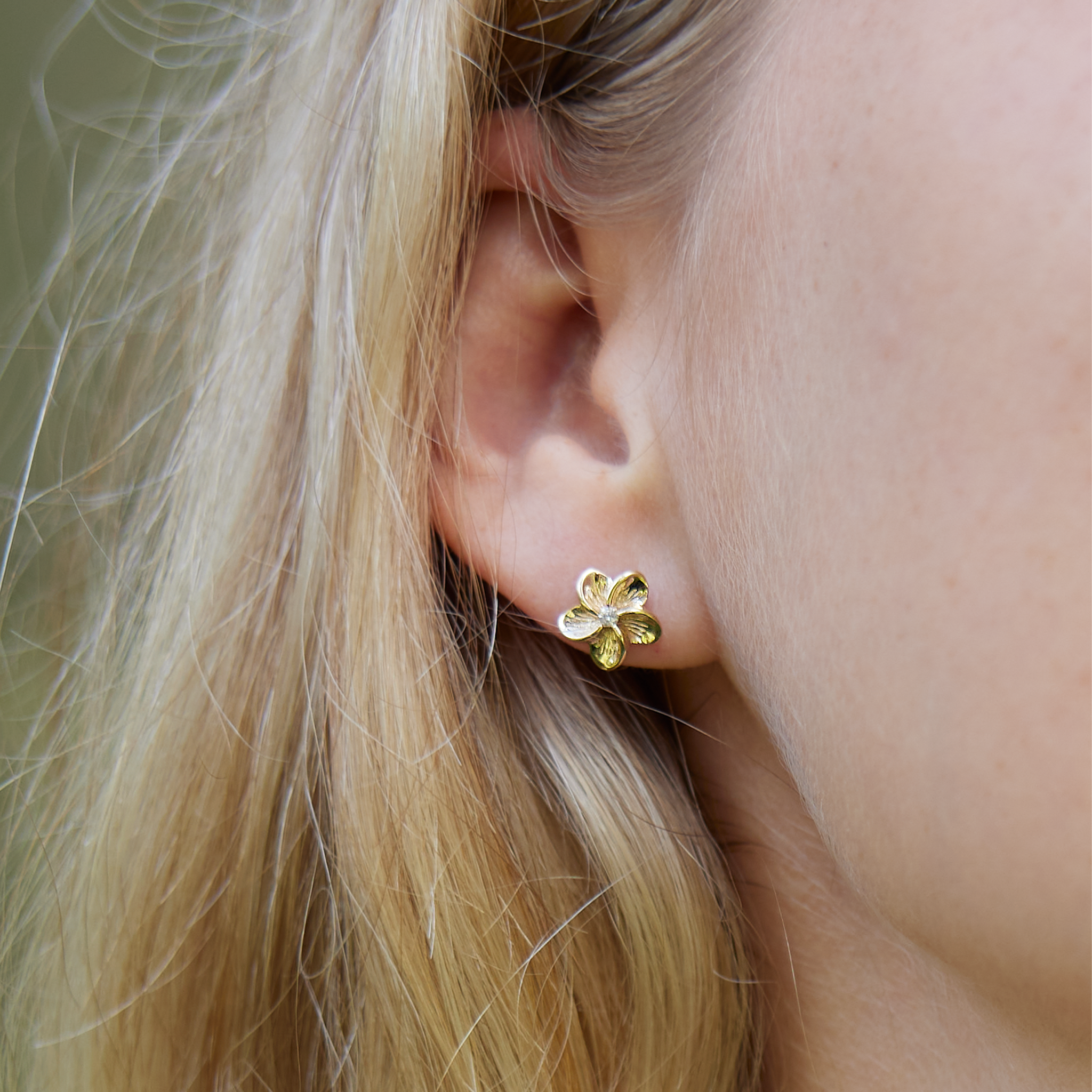 Womanʻs right wear showcasing Hawaiian Heirloom Plumeria Earrings in Gold with Diamonds - 9mm