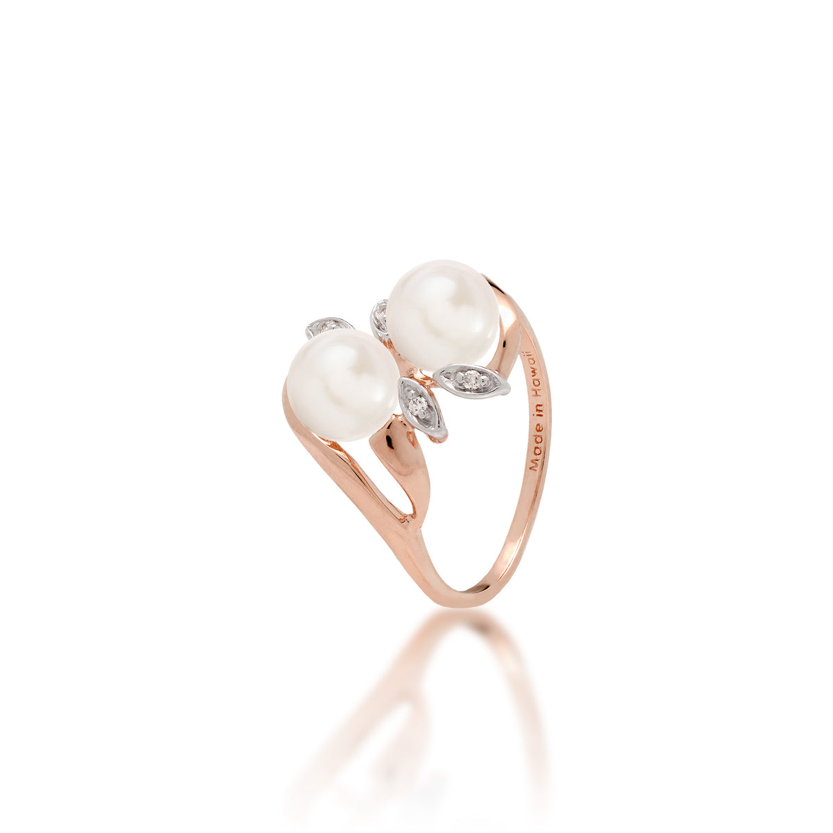 A 14k rose gold ring with two peach freshwater pearls and two diamond accent maile leaves on each side, shown on white background