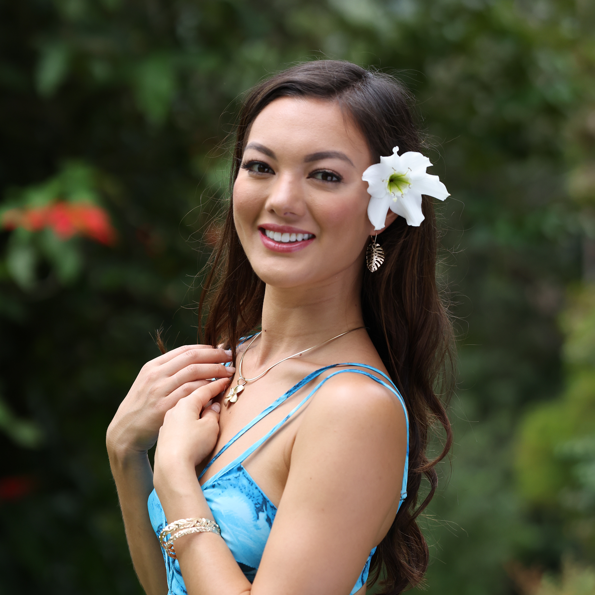 A woman wearing Monstera Earrings in Gold - 30mm - and a Plumeria Pendant - Maui Divers Jewelry