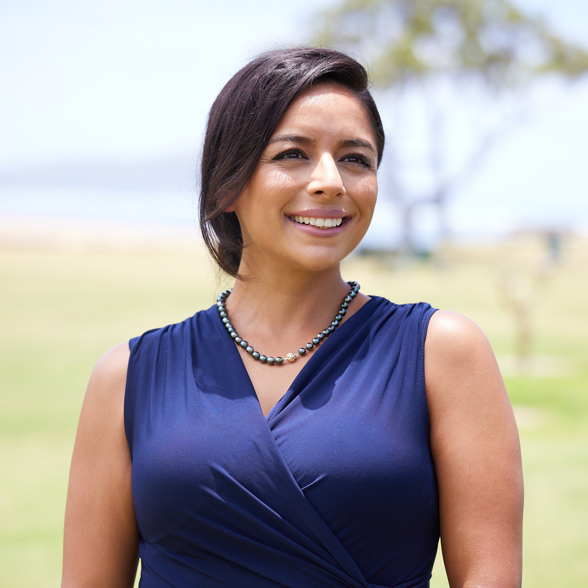 A woman wearing a Tahitian Black Strand  with Magnetic Gold Clasp - Maui Divers Jewelry