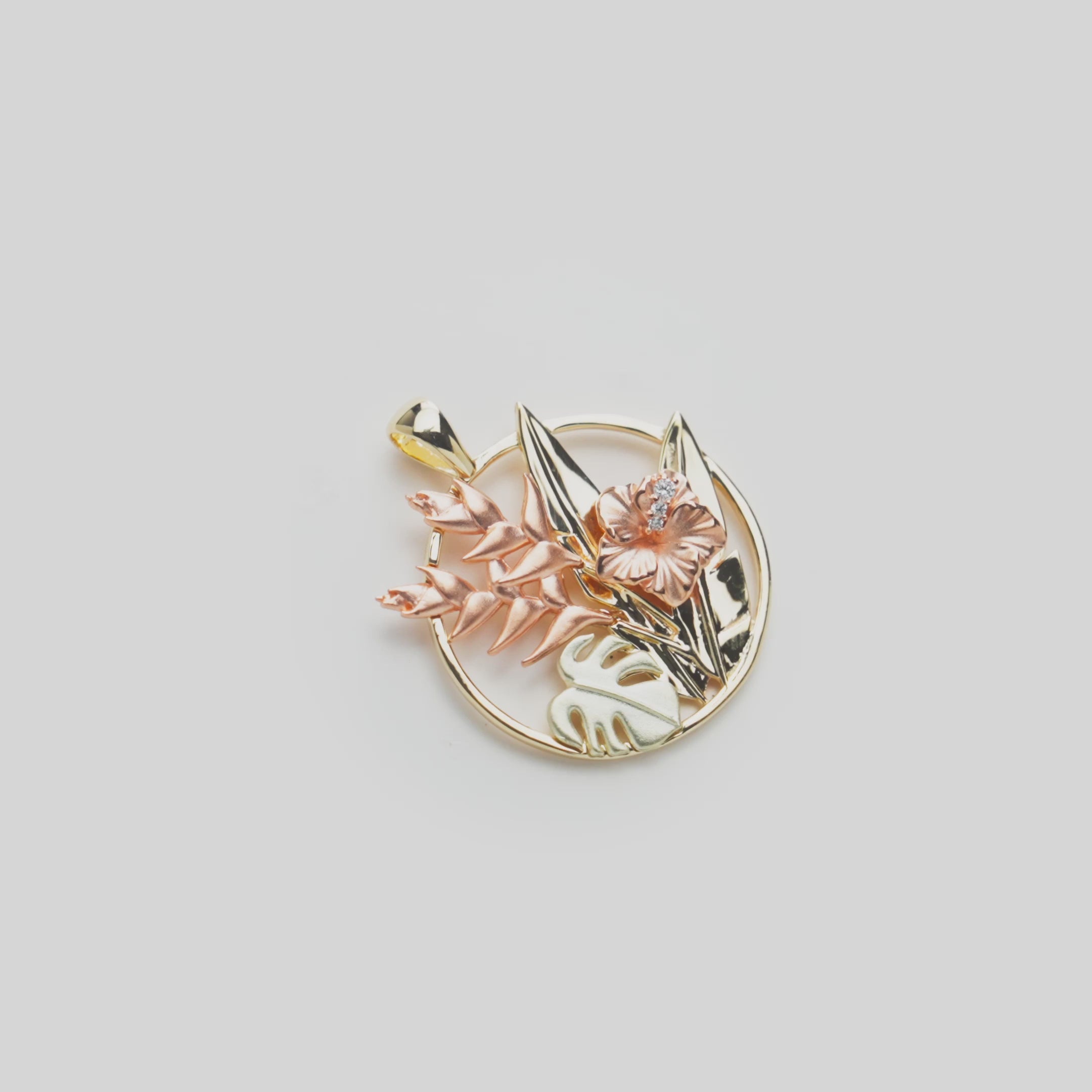 Video of a Hawaiian Gardens Hibiscus Pendant in Tri Color Gold with Diamonds on a white turn table