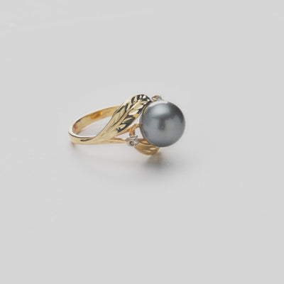 Video showcasing a diamond-cut maile leaf ring in 14k yellow gold with diamond accents and a Tahitian black pearl.