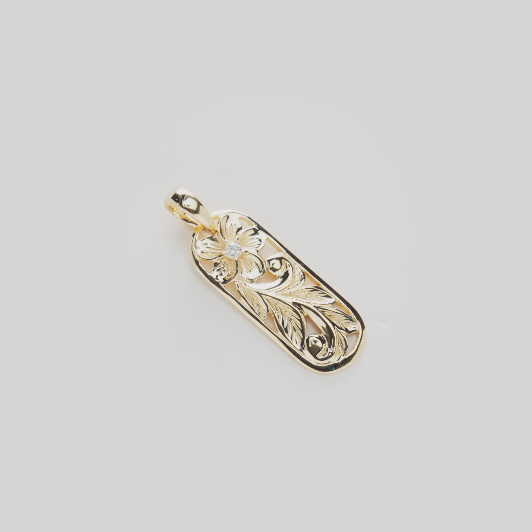 Video of the 24mm Hawaiian Heirloom Plumeria Pendant in 14k Yellow Gold with diamonds turning on a white background