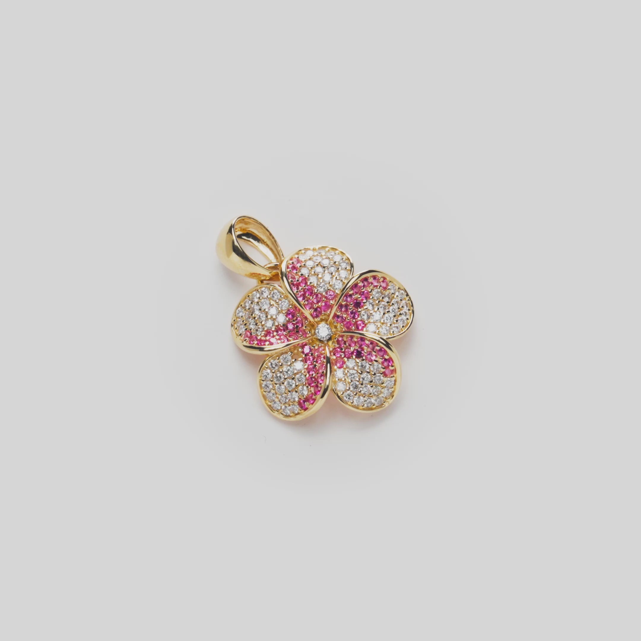Plumeria Pink Sapphire Pendant in Gold with Diamonds on a white turntable