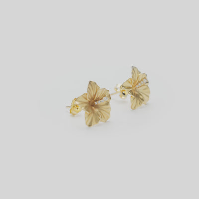 14mm Diamond Hibiscus Stud Earrings in 14k Yellow Gold on a white turntable