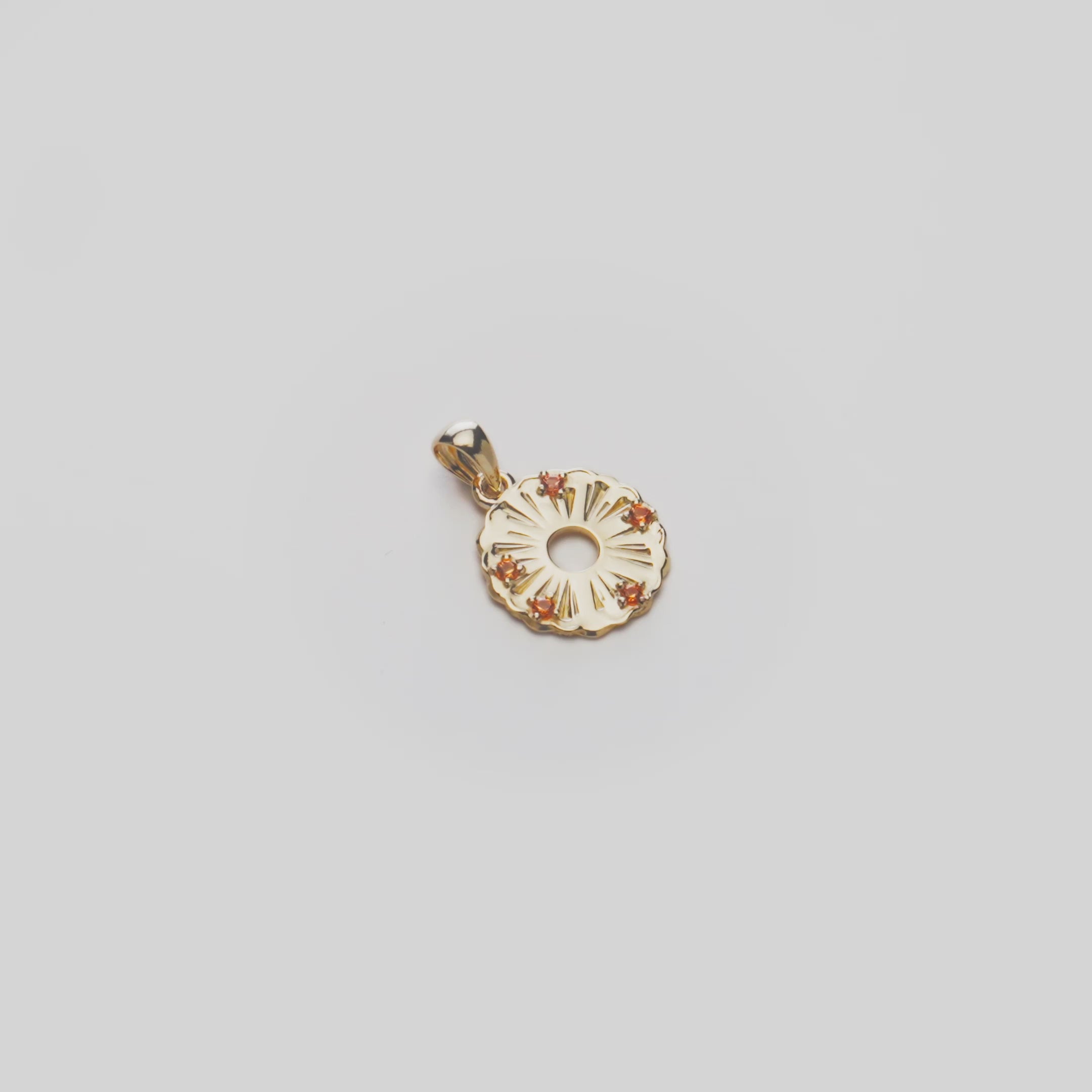 Video of a Round Pineapple Slice Pendant in solid 14k yellow gold with orange sapphires on a rotating white background